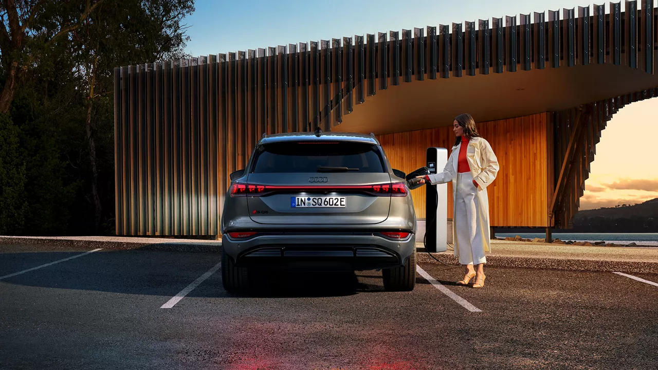 Audi Q6 e-tron parked with sunset behind it