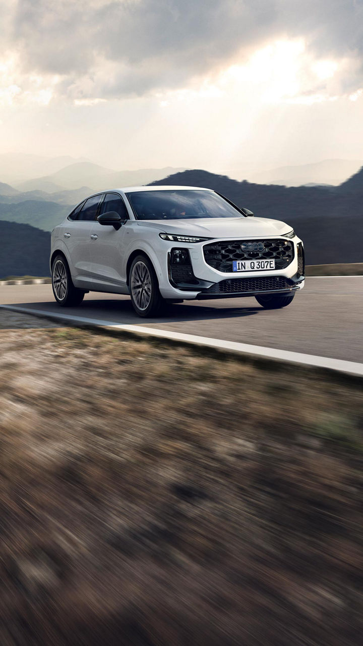 Weisser Audi Q3 Sportback e-hybrid fahrend auf einer Bergstrasse 