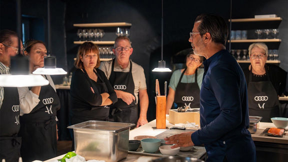 Andreas Caminada neben mehreren Beeten mit Blumen darin