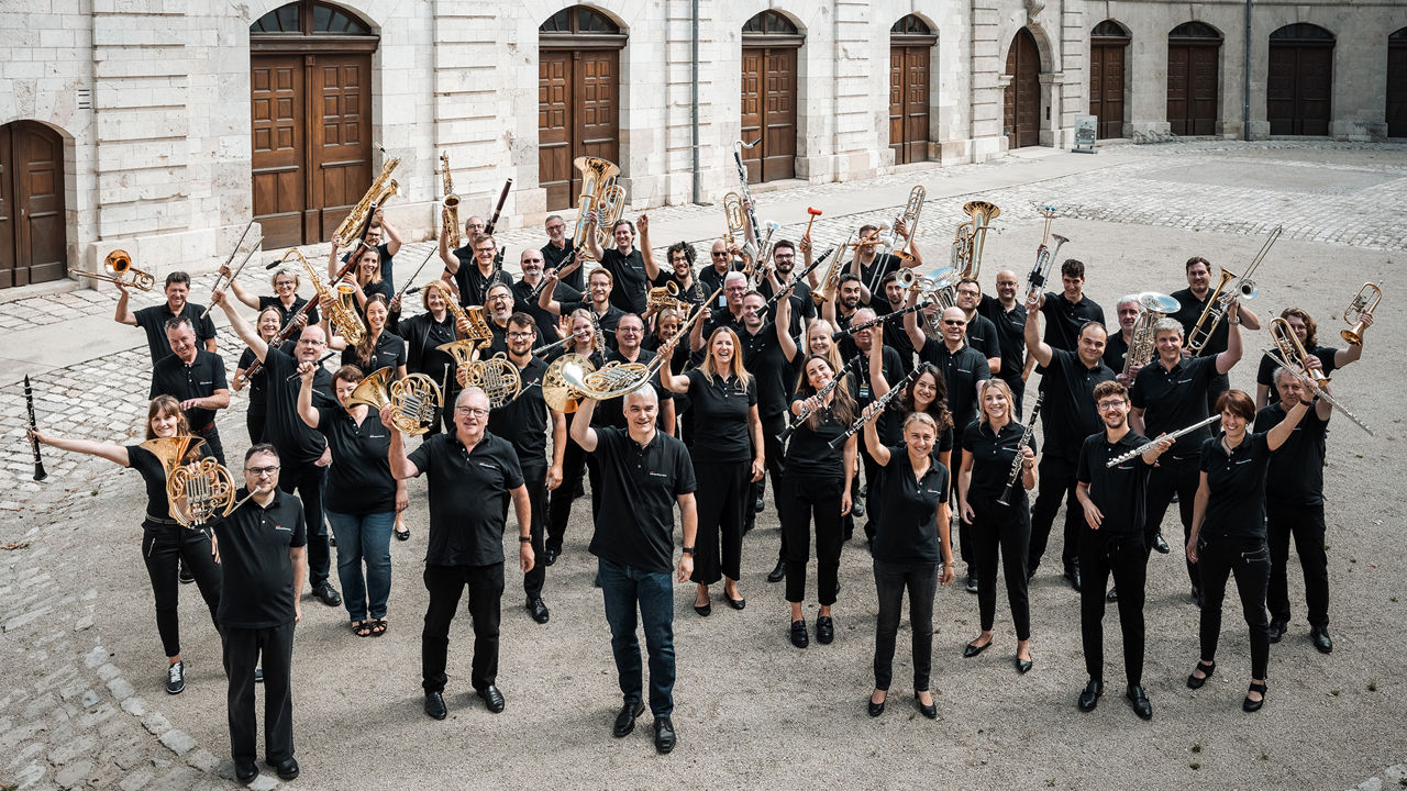 Gruppenaufnahme der Audi Bläserphilharmonie im Innenhof eines Gebäudes im Klenze Park.