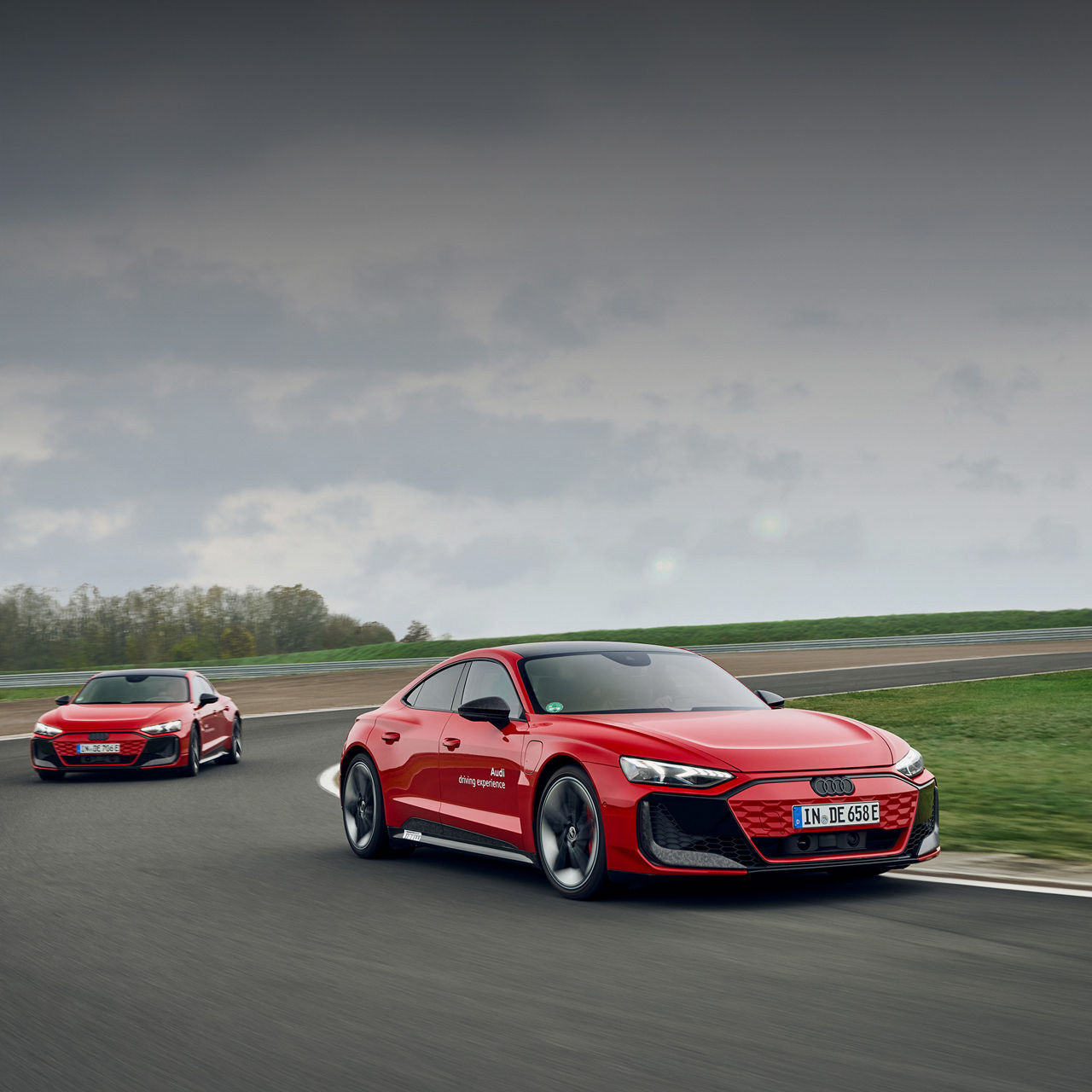 zwei rote Audi RS e-tron GT performance fahren hintereinander auf der Rennstrecke.  Mehr zur Audi training experience
