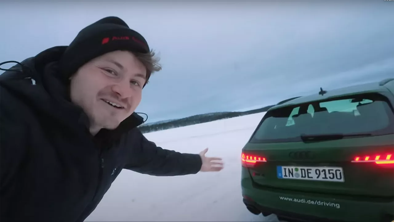 Youtuber Felix von der Laden stands in front of a dark green Audi model in the snow at the Audi ice experience in Finland.