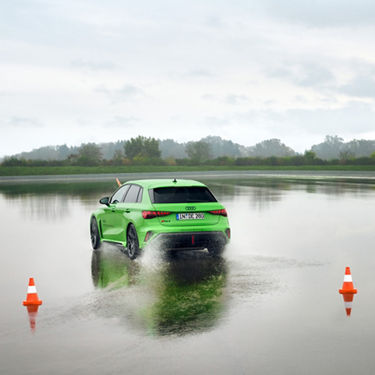 Green Audi RS 3 Sportback on a wet road surface