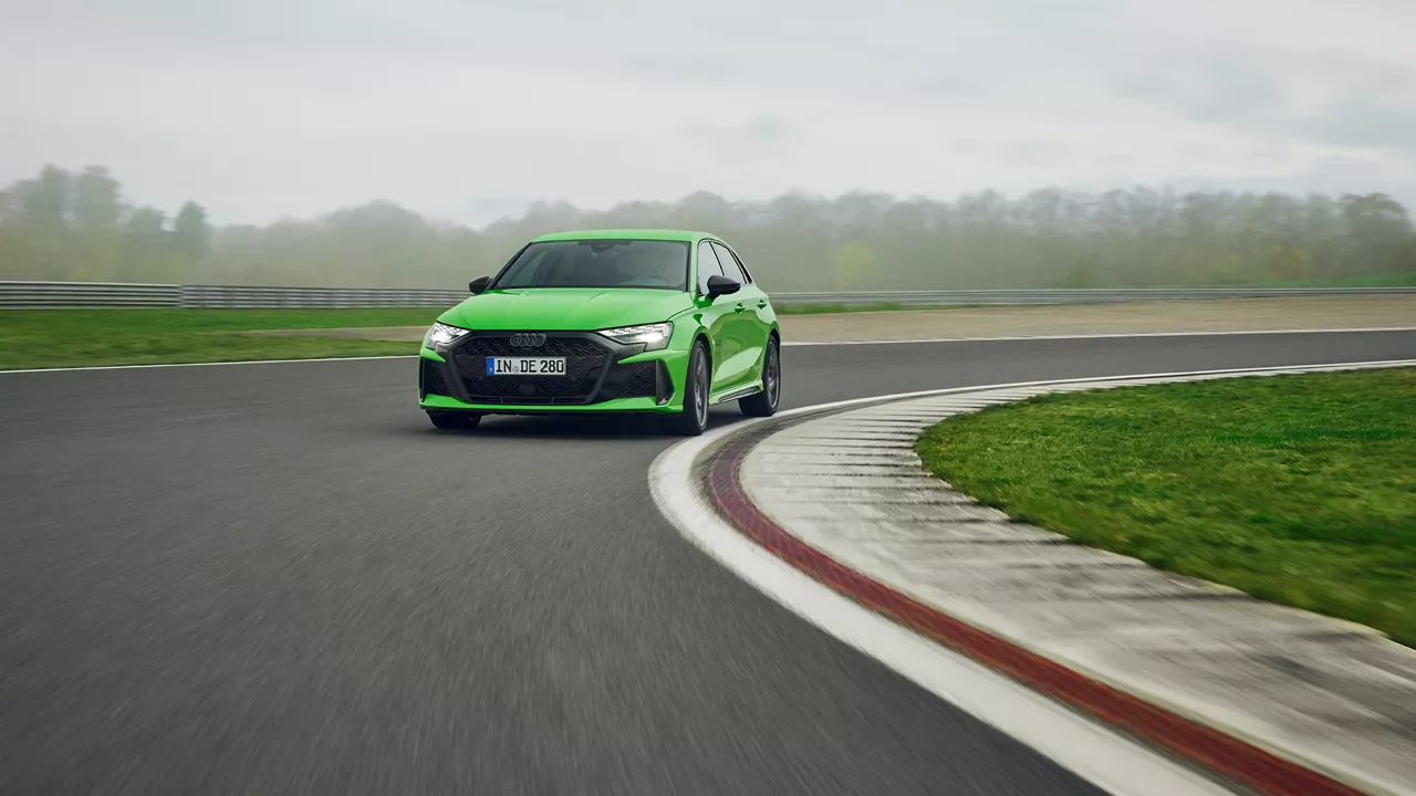 Light green Audi RS 3 Sportback takes a bend on a training ground