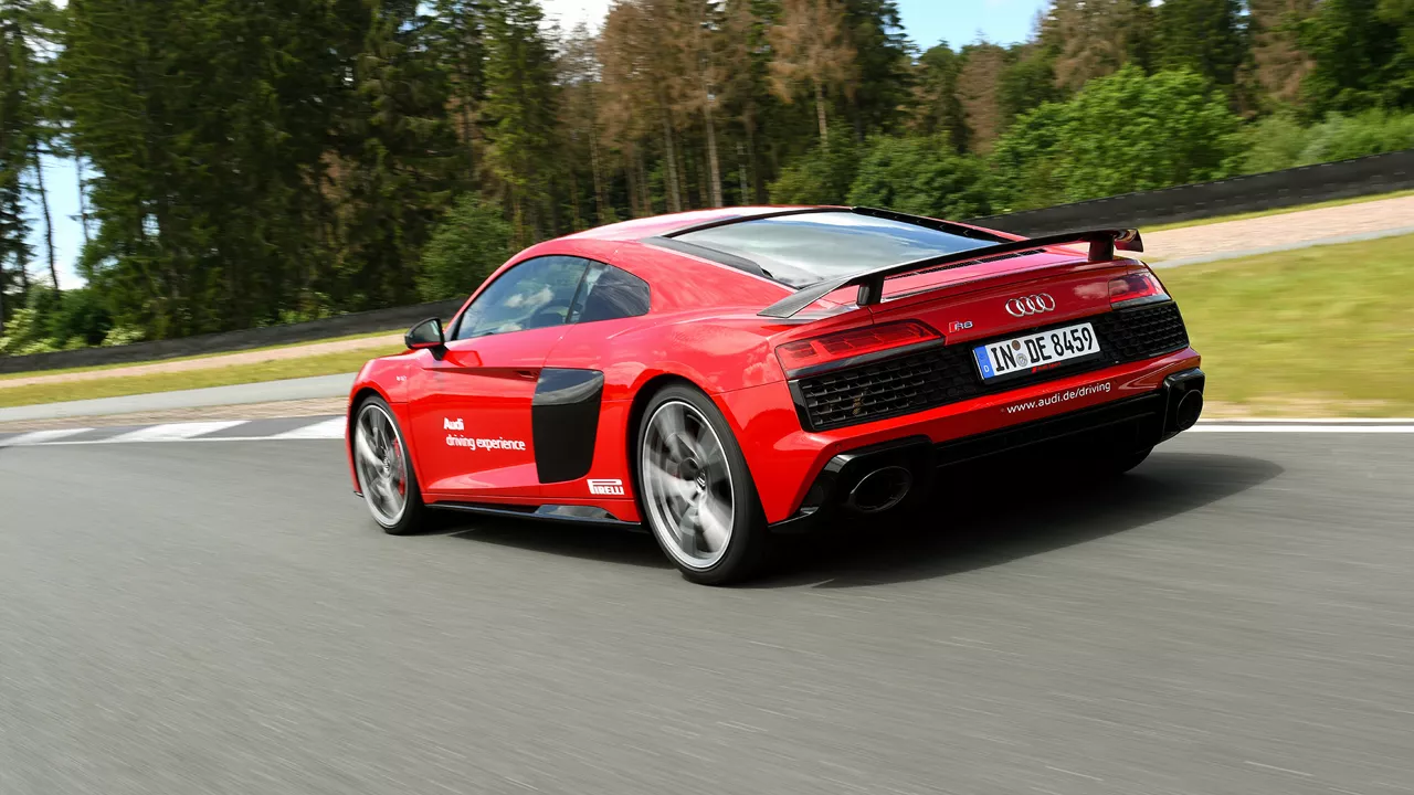 Red Audi R8 Coupé V10 performance quattro driving on the race track, rear view