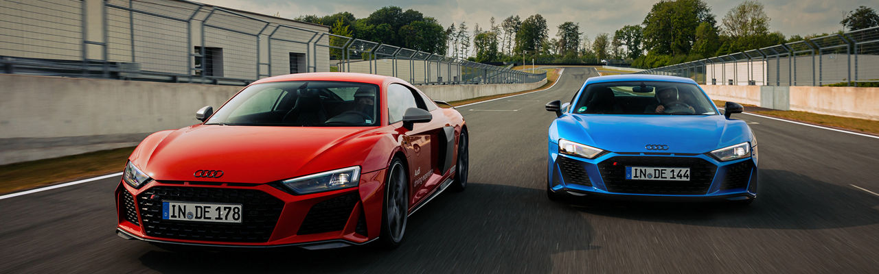 Ein roter und ein blauer Audi R8 Coupé fahren auf einer Rennstrecke in Neuburg, links fährt das rote Modell und fährt ein wenig weiter vorne