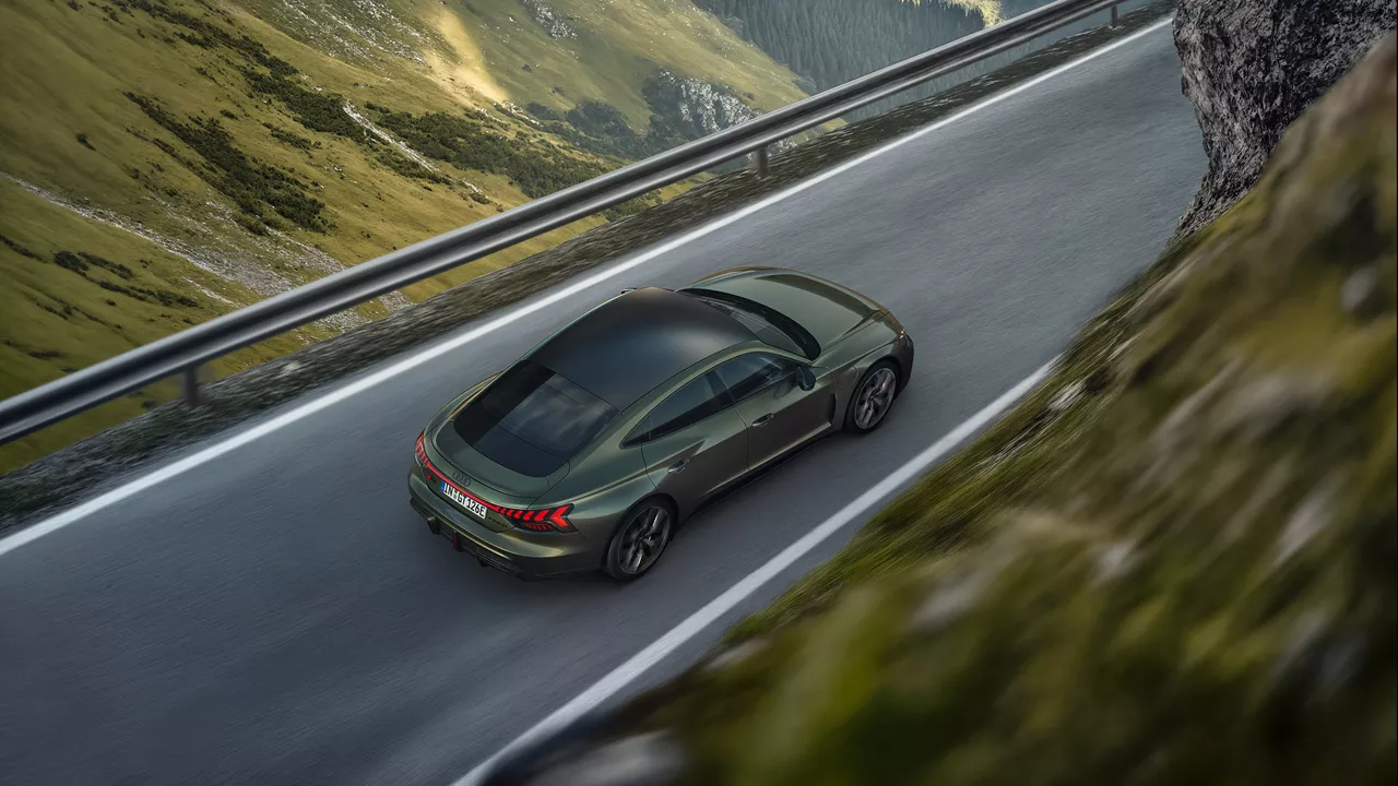 Bird's eye view of dark green Audi RS e-tron GT driving on a road in the mountains