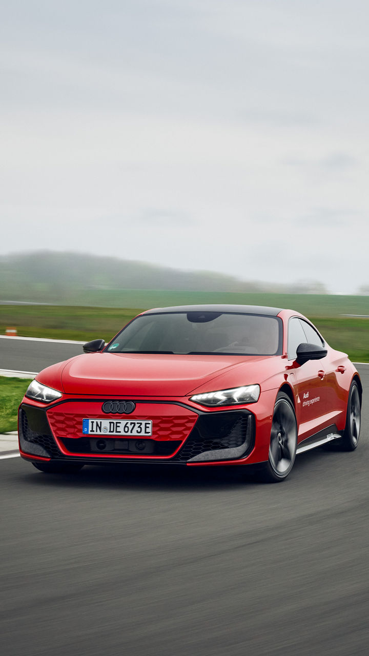 Roter Audi RS e-tron GT performance fährt auf einer Übungsstrecke durch eine Kurve