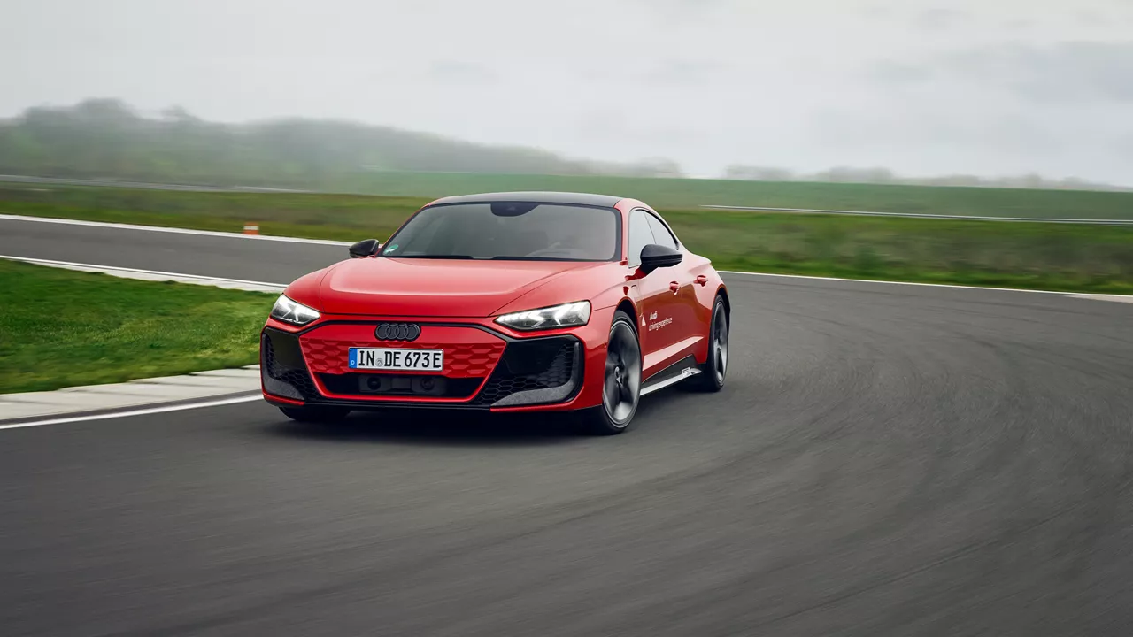 Red Audi RS e-tron GT performance drives through a curve on a practice track