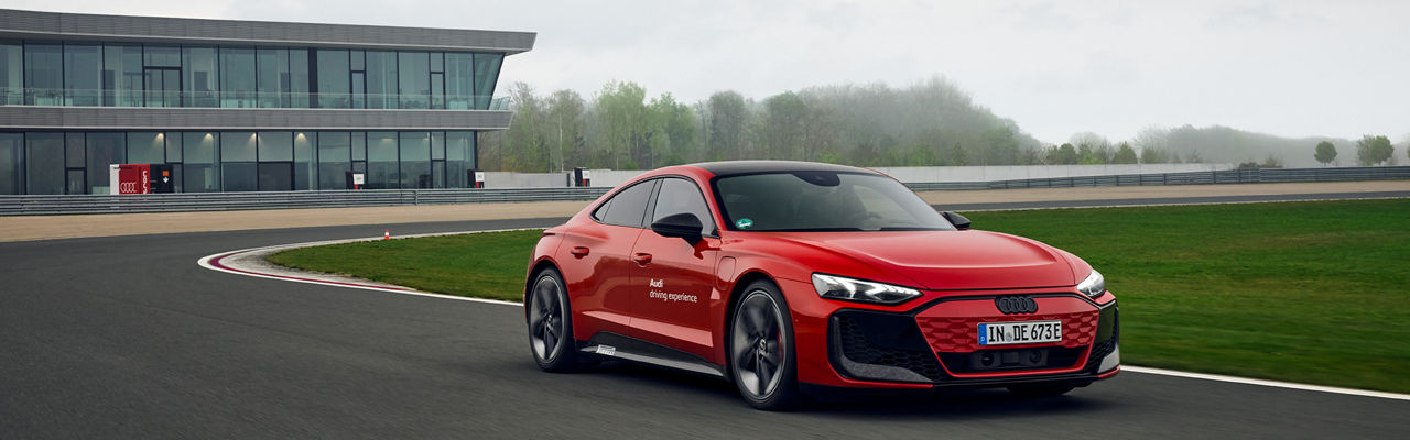 Red Audi RS e-tron GT performance takes a bend on a training grounde
