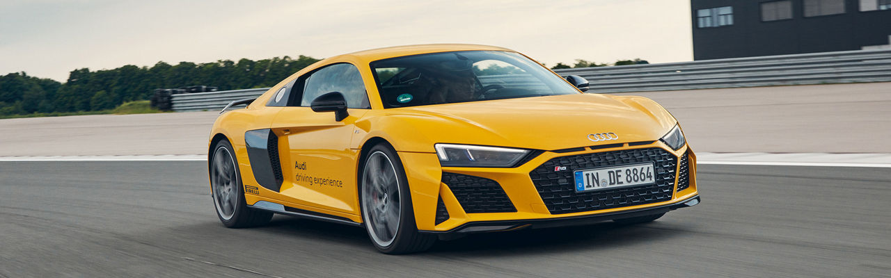 Gelber Audi R8 Coupé fährt auf einer Strecke