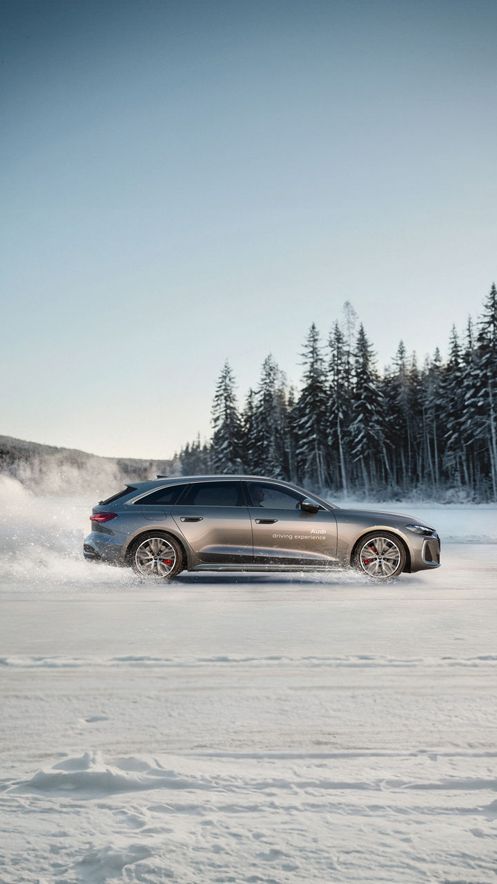 Grauer Audi S5 Avant Seitenansicht, drifted im Schnee