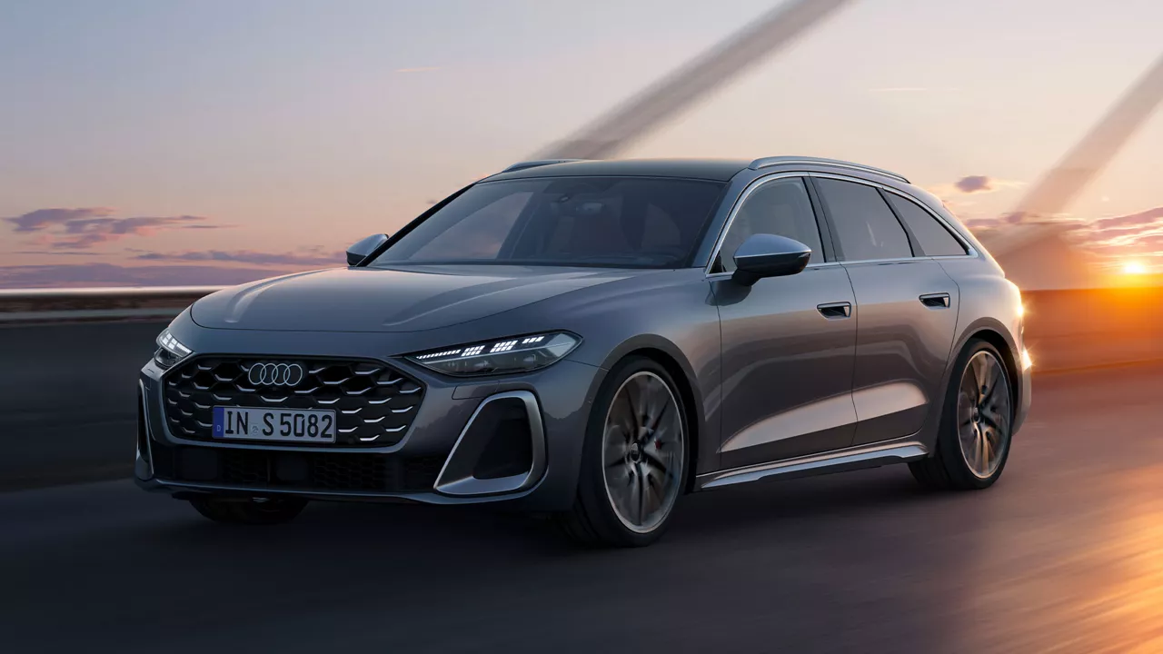 Grauer Audi S5 Avant fährt über Brücke bei Sonnenuntergang, Frontansicht.