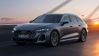 Grauer Audi S5 Avant fährt im Sonnenuntergang auf Straße