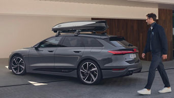 Audi mit einer Dachbox steht vor einem Haus