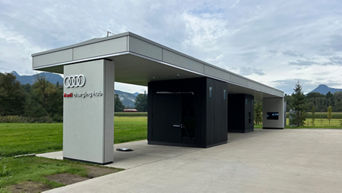Audi Charging Hub Kiefersfelden bei Tag inmitten einer Grünfläche