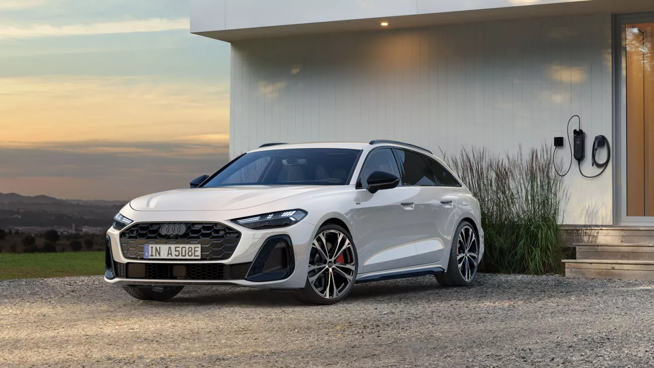 Weißer Audi A5 Avant e-hybrid quattro vor einem modernen Haus