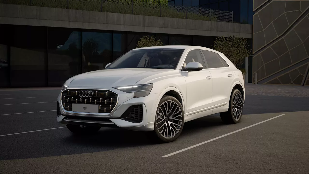 Weißer Audi Q8 SUV steht auf einem Parkplatz vor moderner Architektur, schräg von vorn aufgenommen.