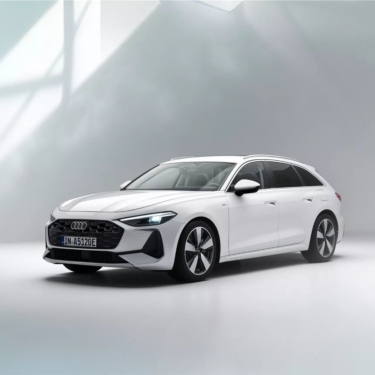 Ein weißer A5 Avant 220 kw e-hybrid steht seitlich vor einem beigen Gebäude
