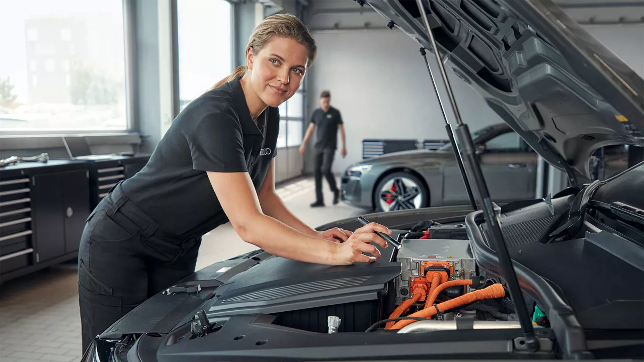 Audi Mitarbeiterin inspiziert Fahrzeug in der Werkstatt