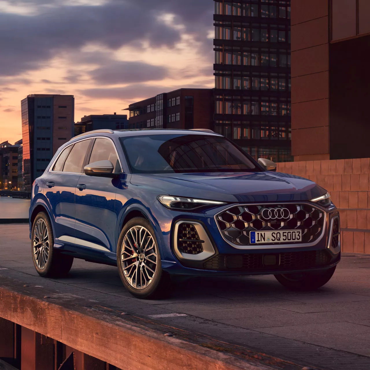 Ein blauer Audi SQ5 SUV steht vor modernen Gebäuden