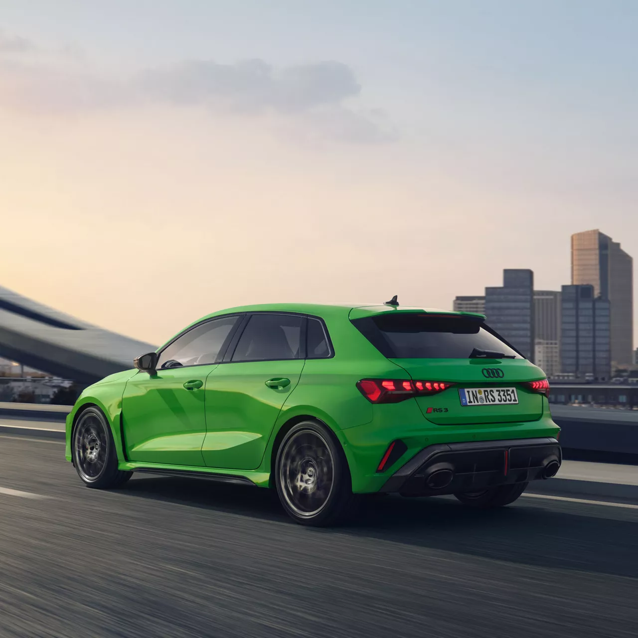 Ein grüner RS3 Sportback fährt auf einer Straße neben einer Großstadt