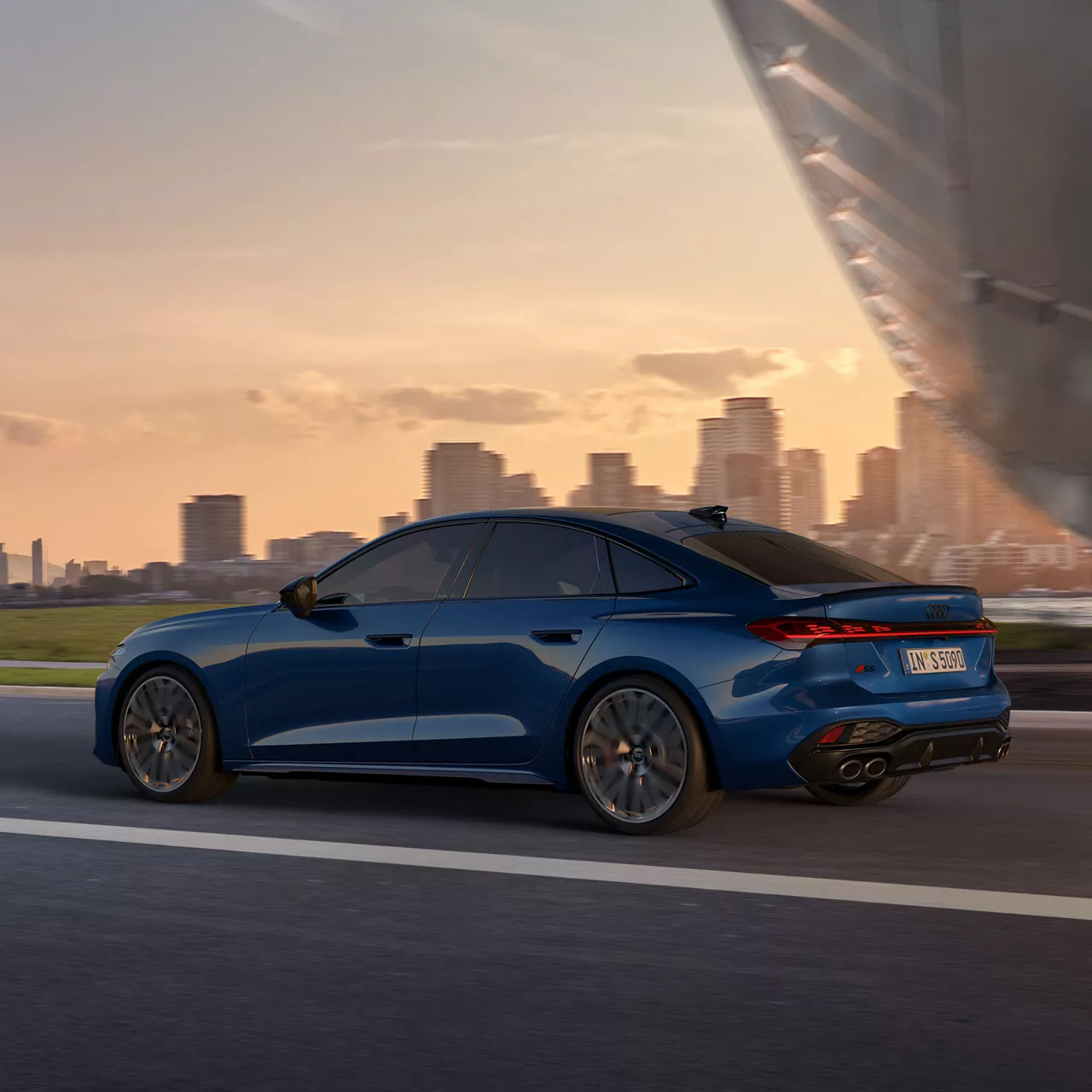 Eine blaue S5 Limousine fährt auf einer Straße in die Großstadt