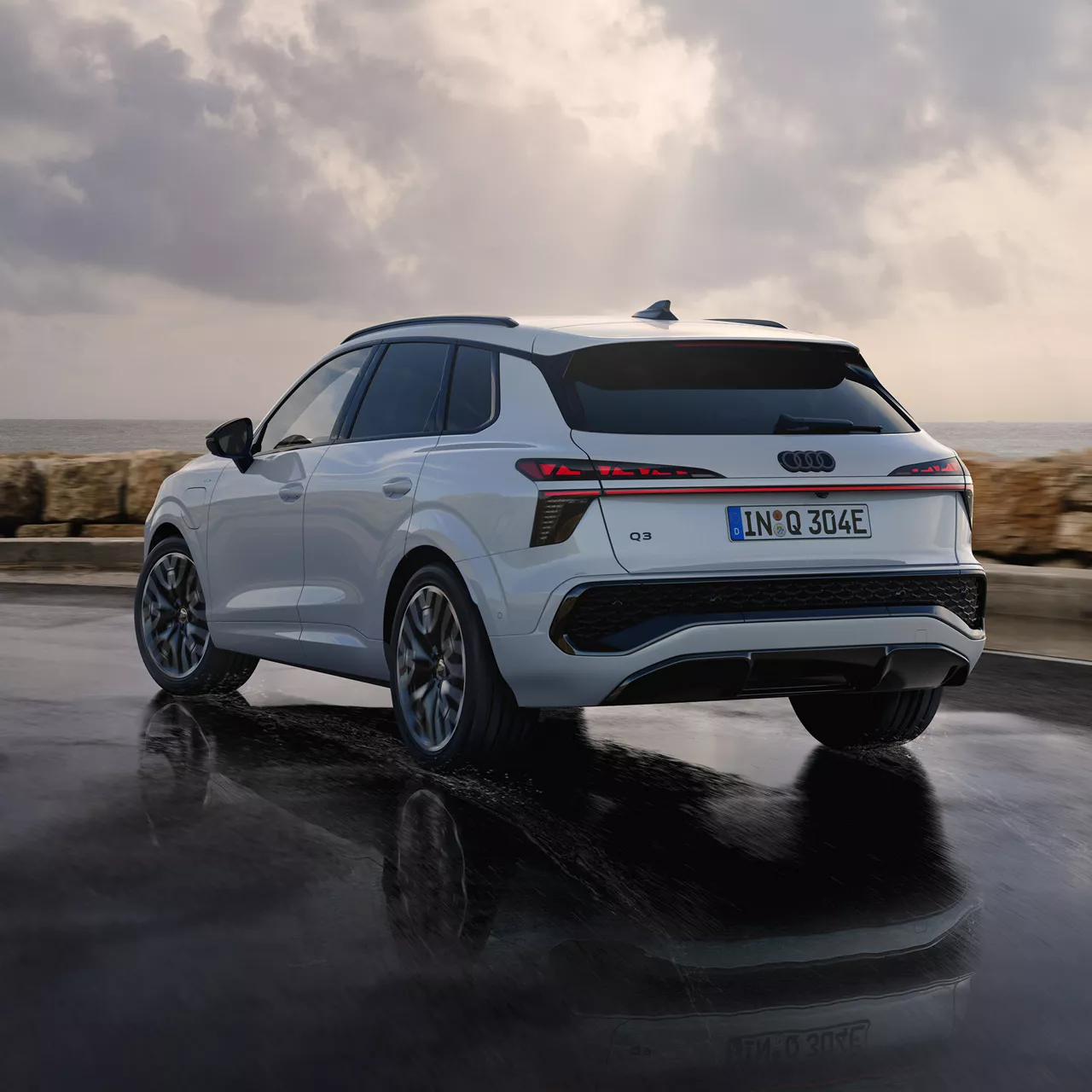 Weißer Audi vor einer Landschaft in der Seitenansicht