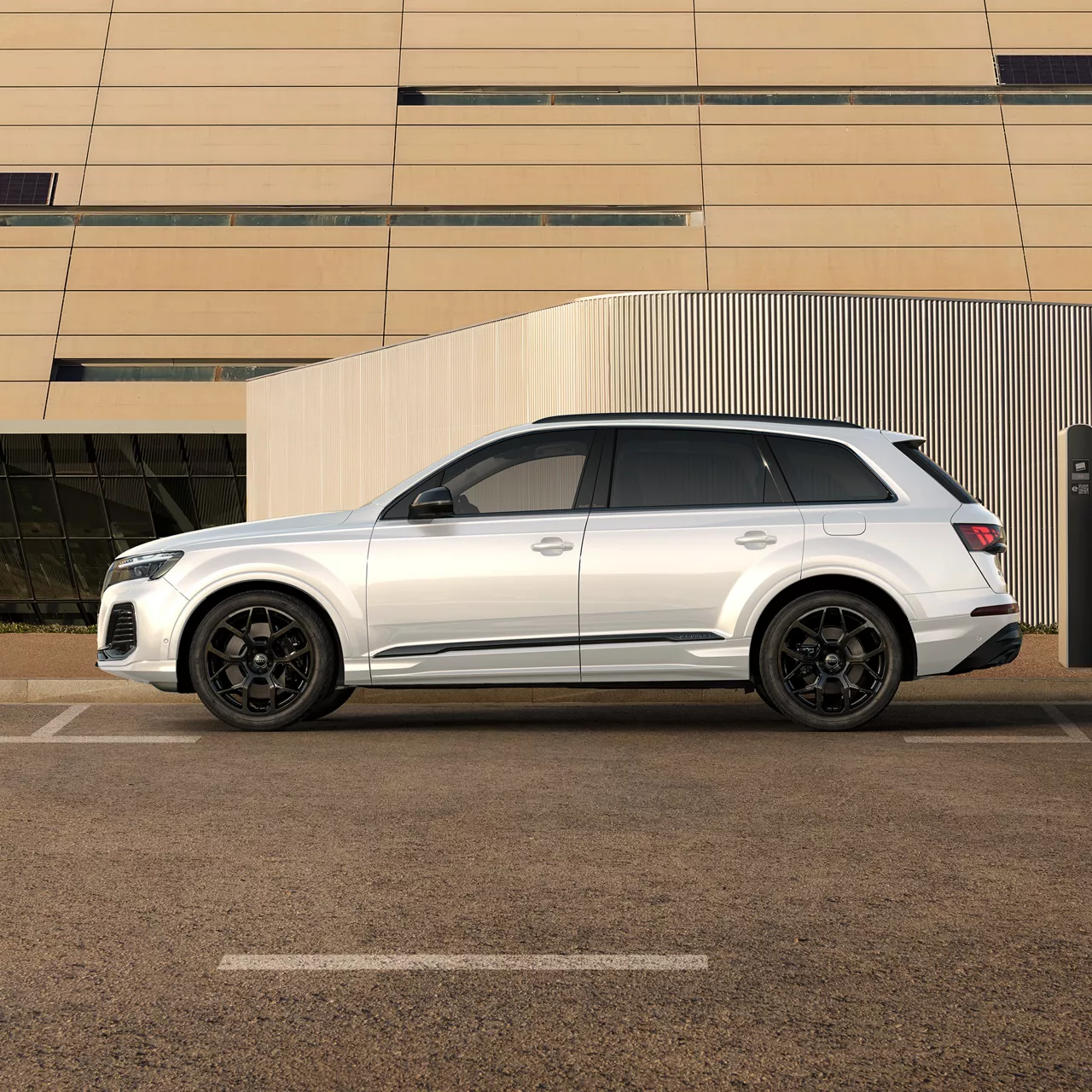 Ein weißer Q7 TFSI e fährt auf einer Straße in einer Stadt