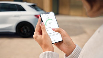 Jemand hat ein Handy in der Hand und man sieht die Charge and Fuel App offen