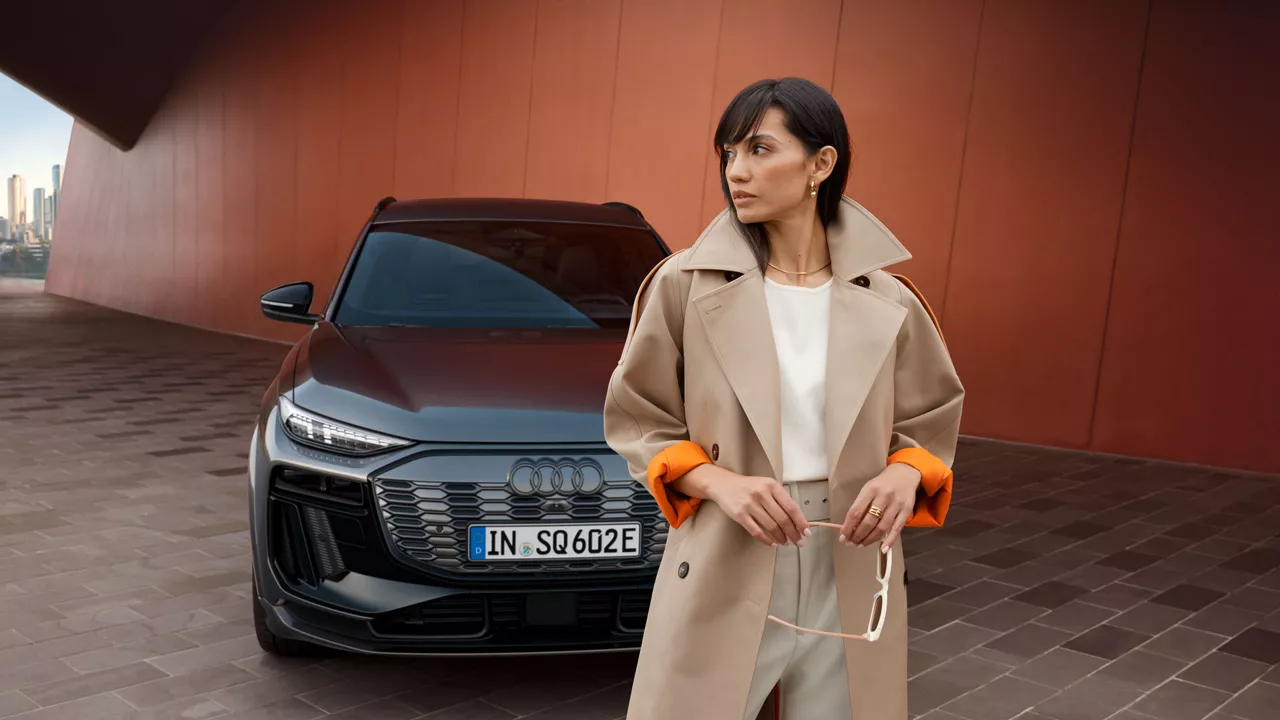 Eine Frau neben wienem weißen Audi 