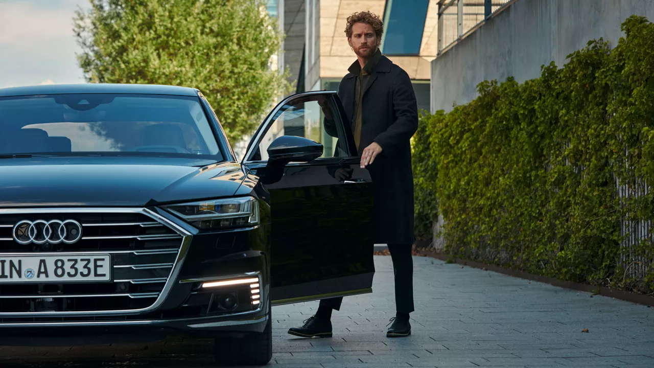 Ein Mann steigt in einen schwarzen Audi e-tron