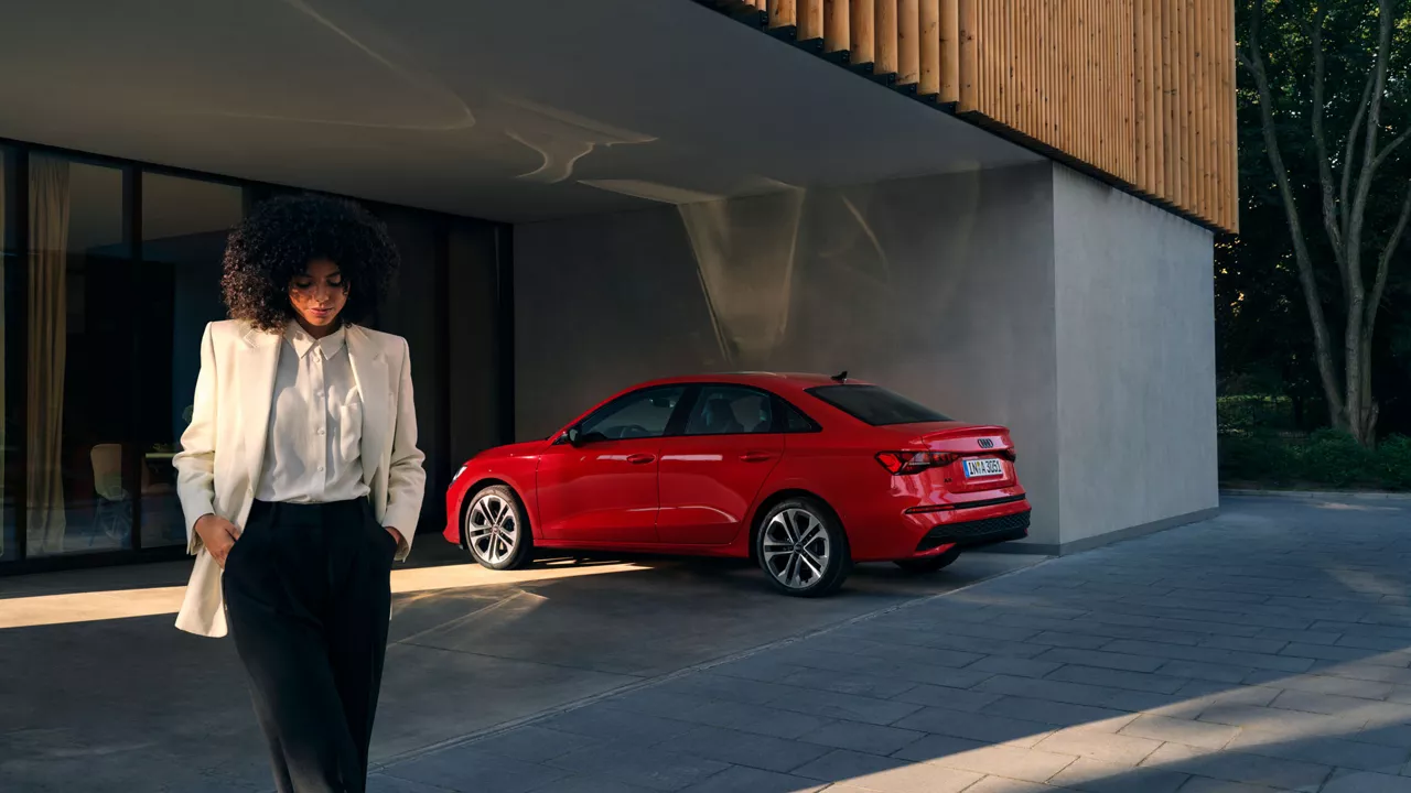 Eine Frau steht vor einem roten Audi