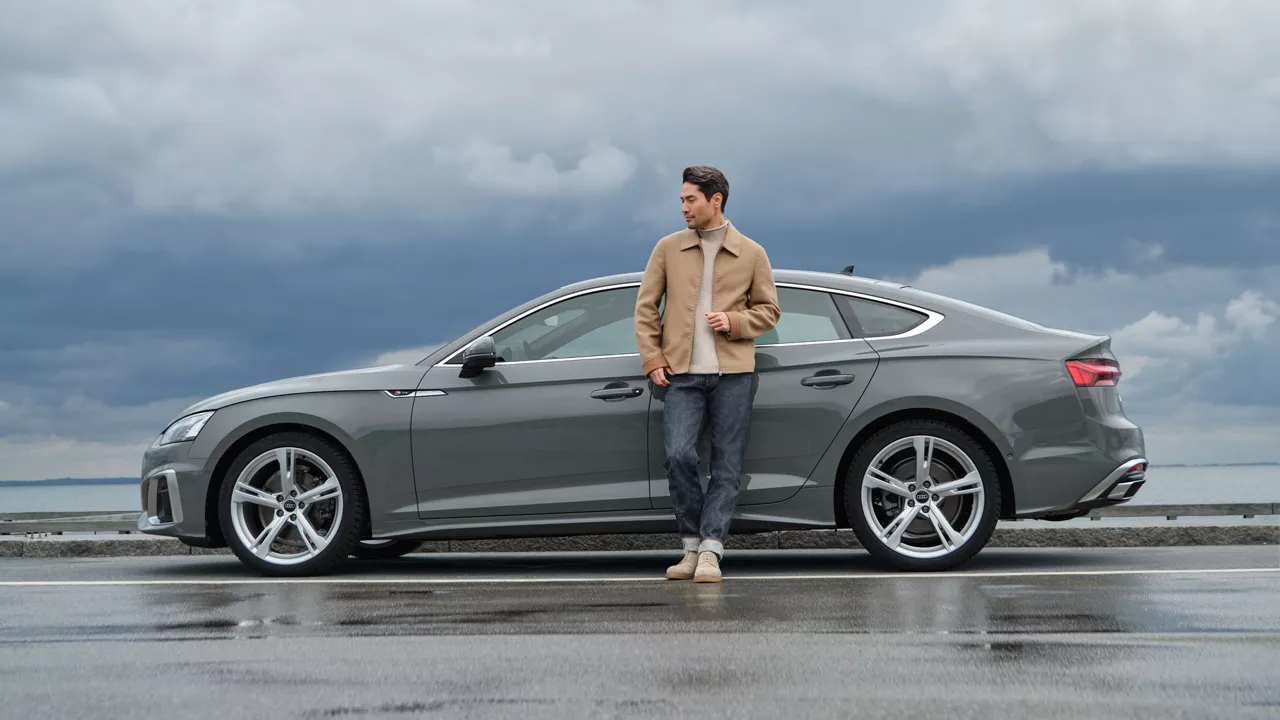 Ein Mann steht vor einem Audi