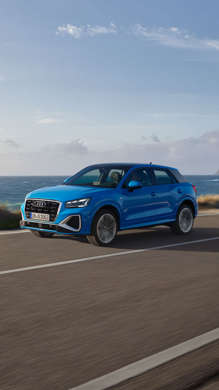 EIn blauer Audi fährt auf einer Straße