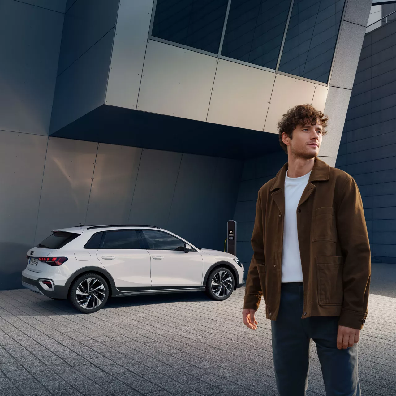 Ein Mann steht vor einem weißem Audi