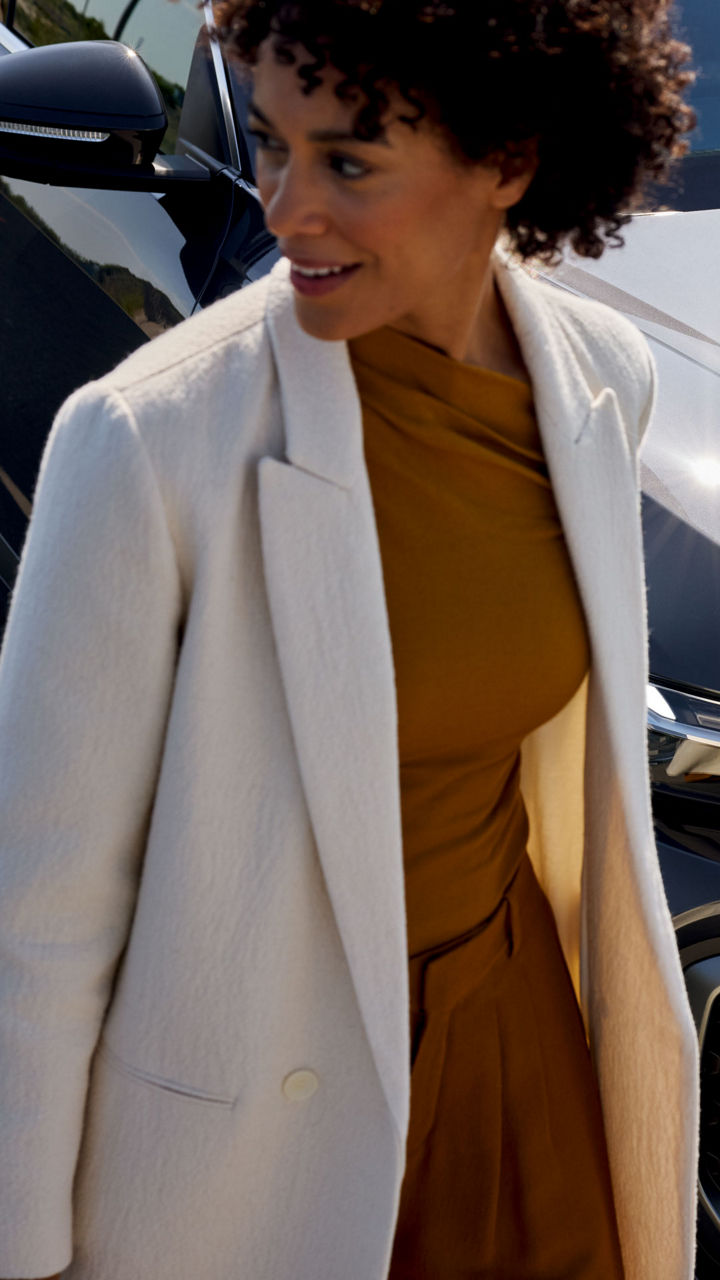 Eine Frau läuft vor einem blauen Audi