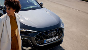 Eine Frau läuft an einem Audi vorbei