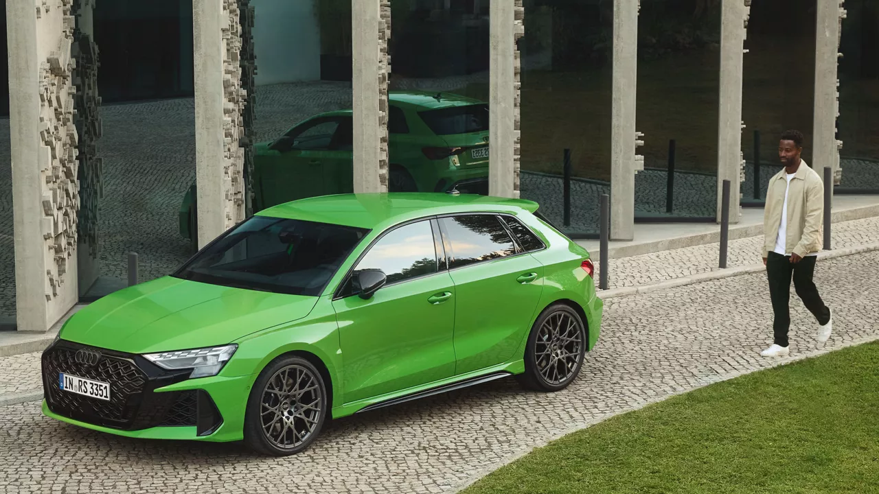 Ein Mann läuft zu einem grünen Audi