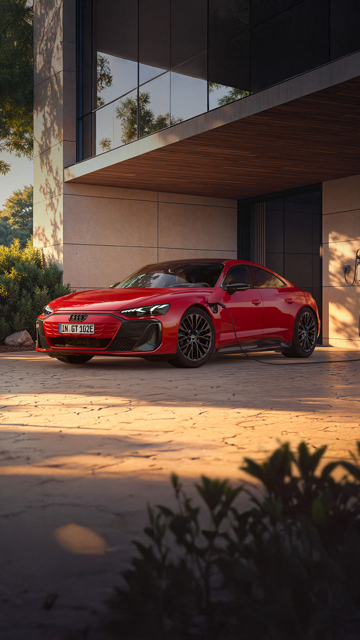 Der neue Audi e-tron GT lädt vor moderner Architektur.