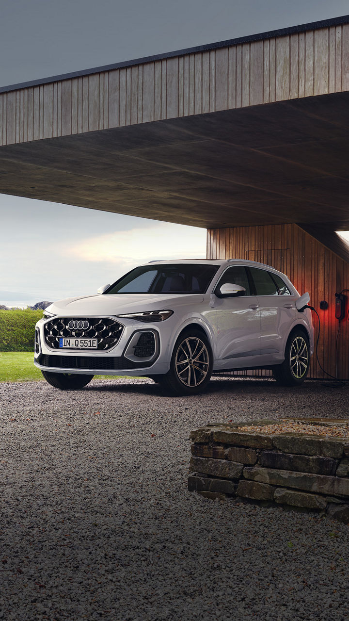 Der neue Q5 SUV e-hybrid vor modernem Bungalow.