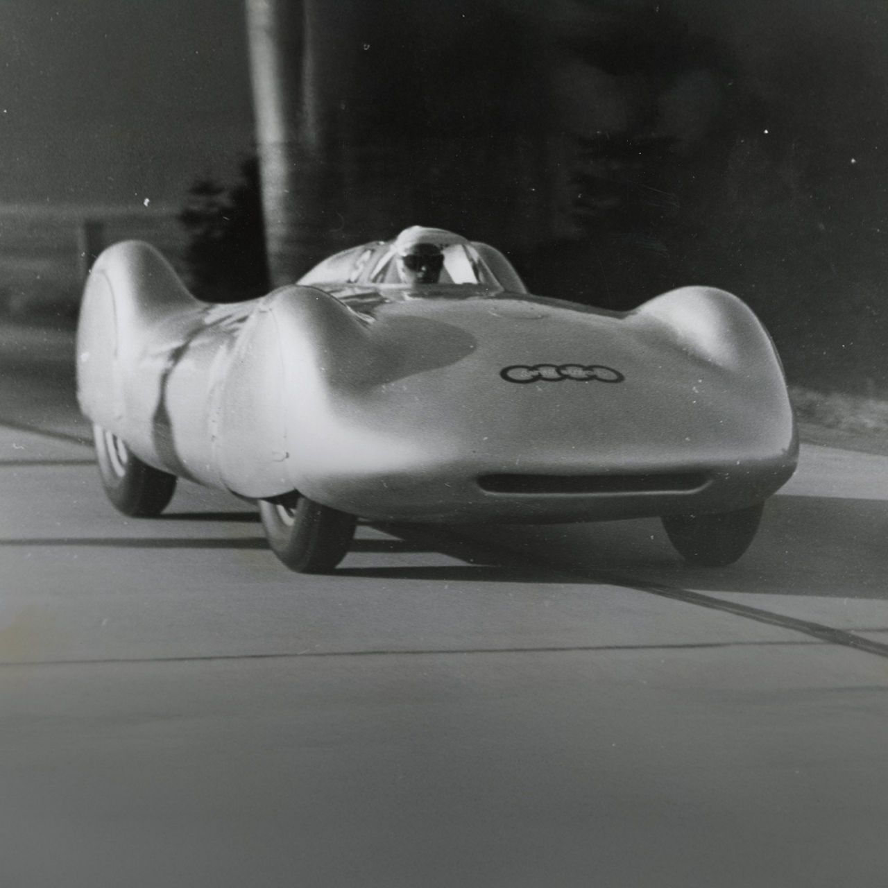 Historische Schwarz-Weiß-Aufnahme von Bernd Rosemeyer in seinem Auto Union Typ C von 1937.