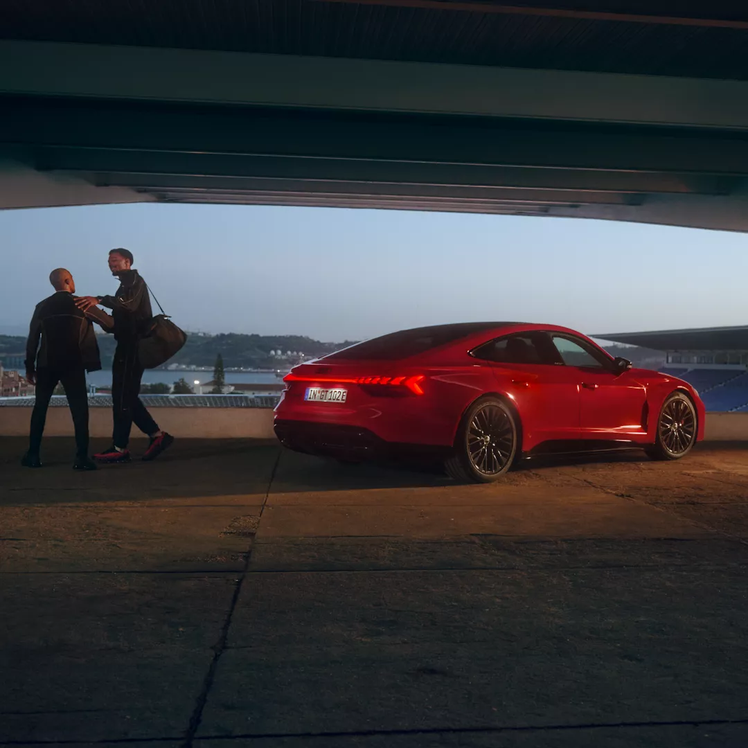 To personer ved siden af en rød e-tron GT  