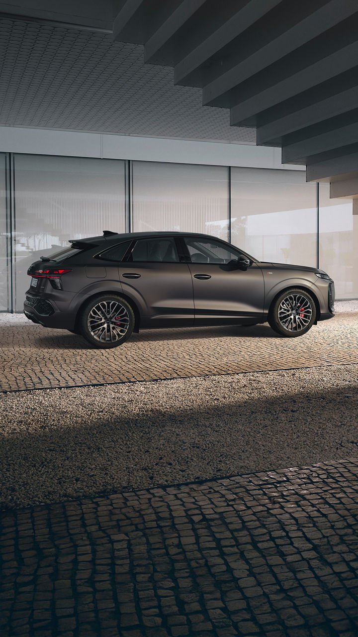 Pruuni värvi Audi Q3 Sportback külgvaates maja kõrval parkimas