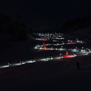 Foto de los esquiadores realizando el descenso por la pista de Baqueira Beret en la e-tron ski night.