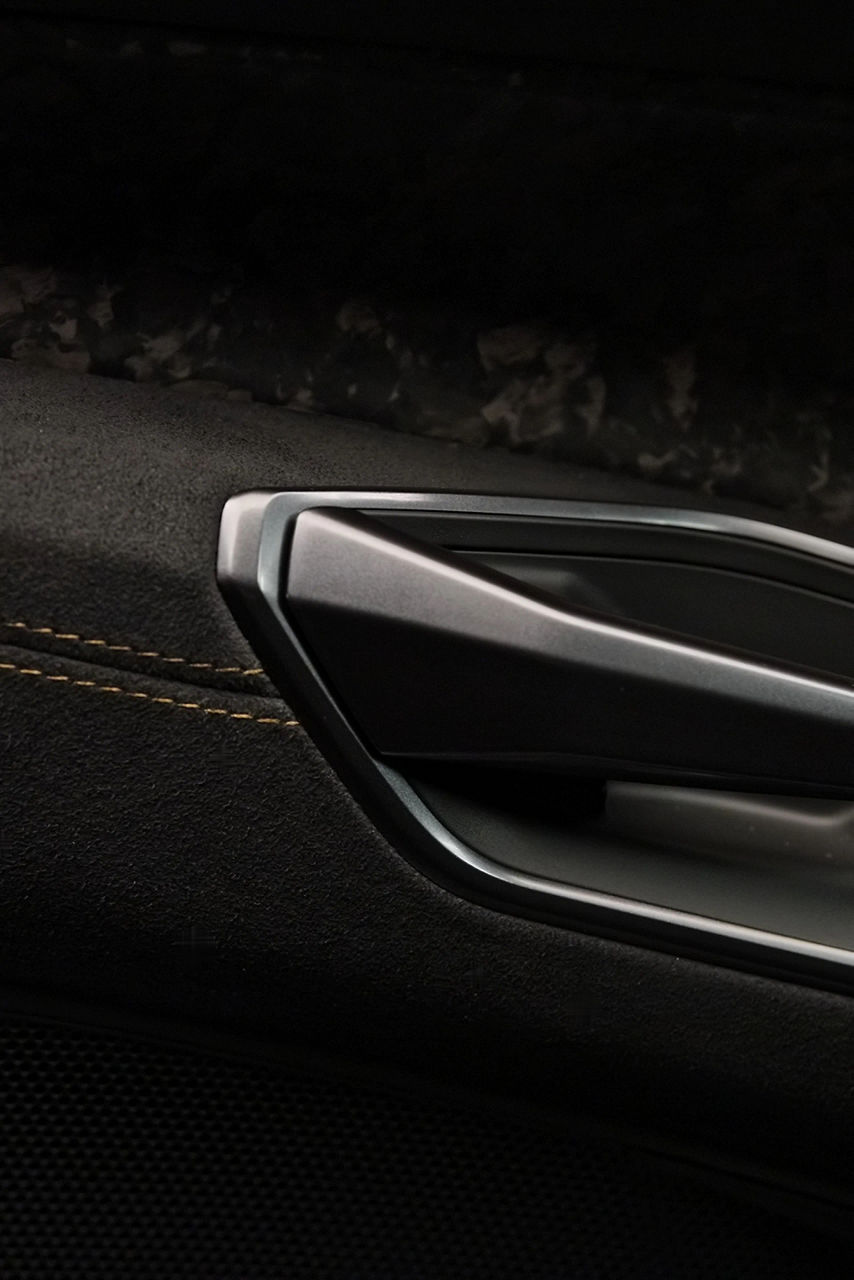L'intérieur de la Nouvelle Audi RS e-tron GT performance¹ est orné de surpiqûres vertes serpentines. Le camouflage en carbone de l'extérieur se retrouve notamment dans les moulures de porte.