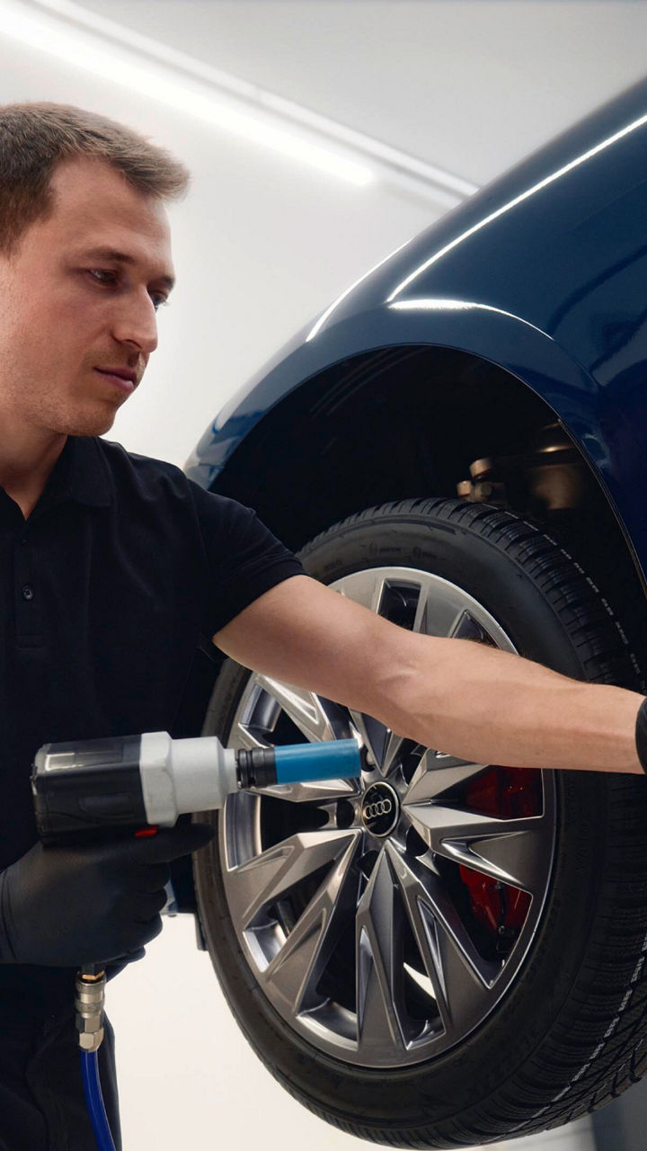 Due uomini effettuano una valutazione su un veicolo Audi, per eventuali inserimenti di Ricambi Originali Audi.