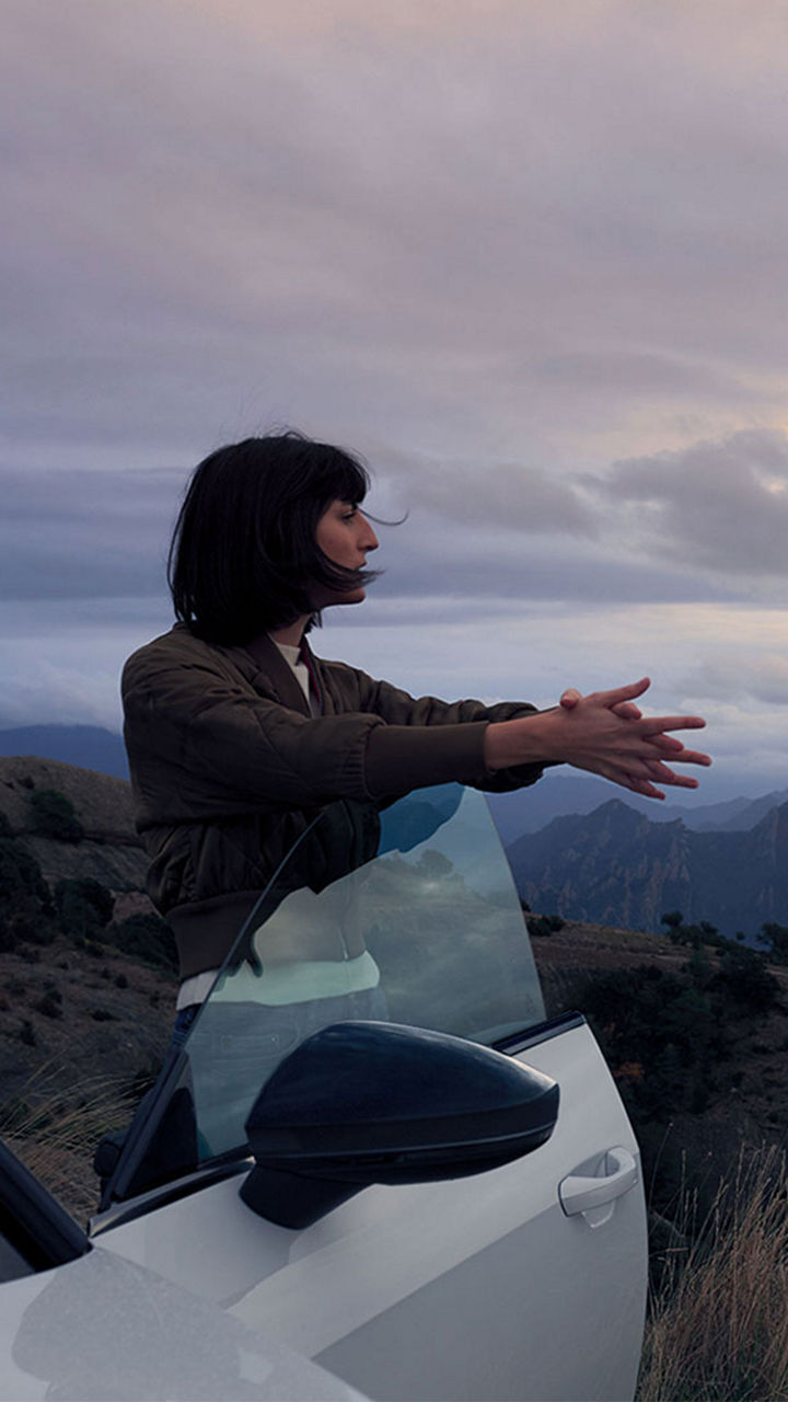 Woman standing next to car