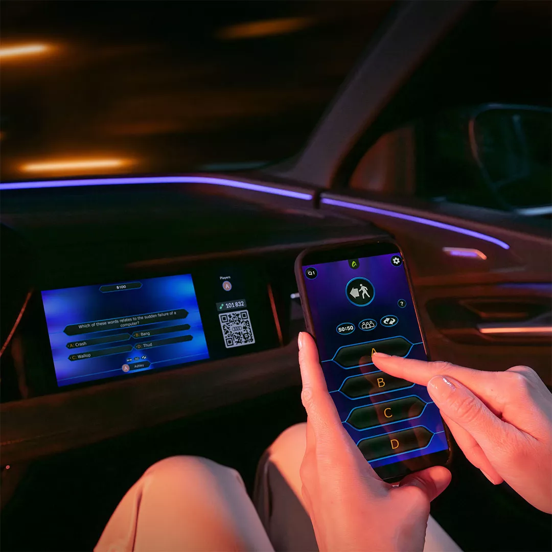 Mobiltelefonen brukes som kontroller til å spille på skjerm i bilen.