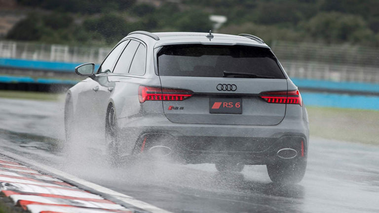 En grå RS 6 Avant Performance som kör på ett blött underlag sedd bakifrån
